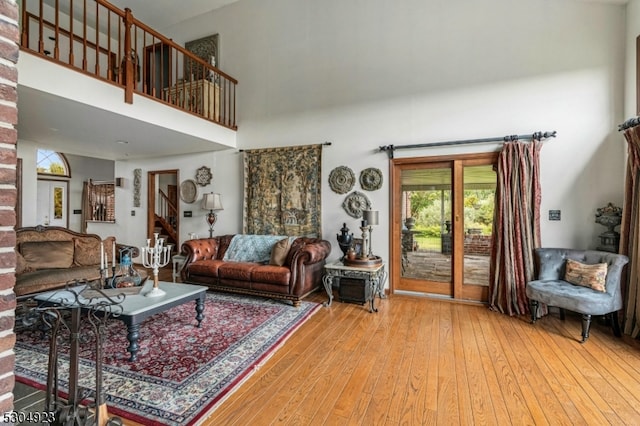 living room featuring a towering ceiling and hardwood / wood-style floors