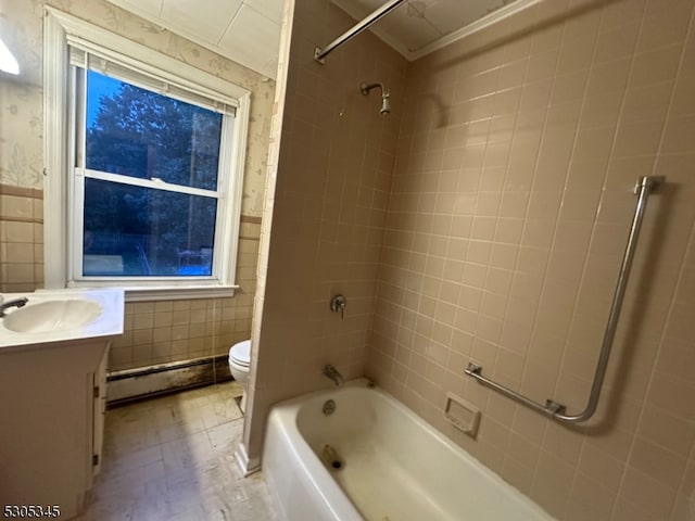 full bathroom featuring tiled shower / bath, baseboard heating, vanity, tile walls, and toilet