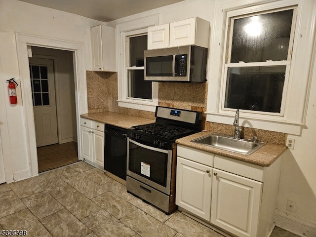 kitchen with light tile patterned floors, sink, stainless steel appliances, and decorative backsplash