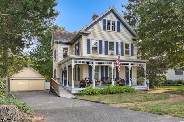 view of front of home with a garage, a porch, and an outdoor structure