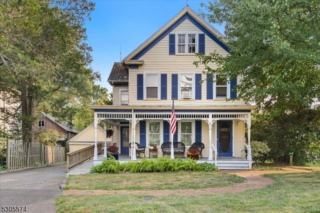 view of front facade featuring covered porch and a front lawn