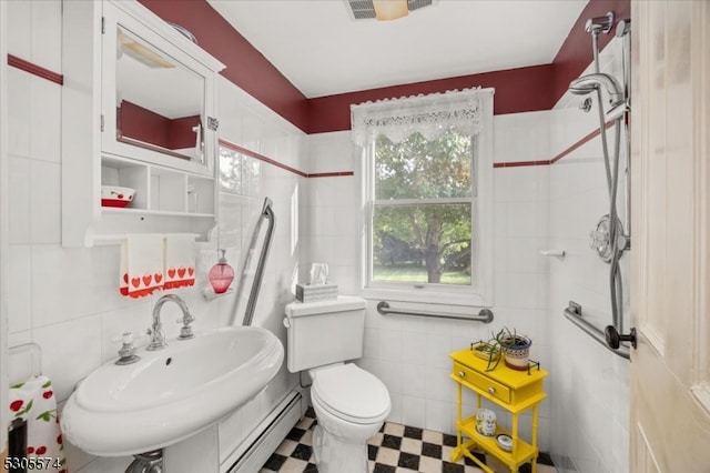 bathroom featuring tile patterned flooring, tile walls, toilet, and a baseboard heating unit