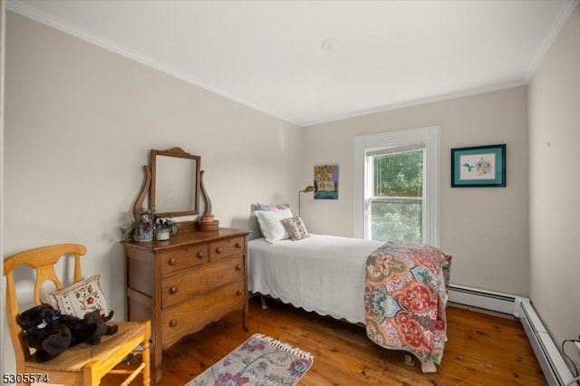 bedroom featuring a baseboard heating unit, hardwood / wood-style flooring, and ornamental molding