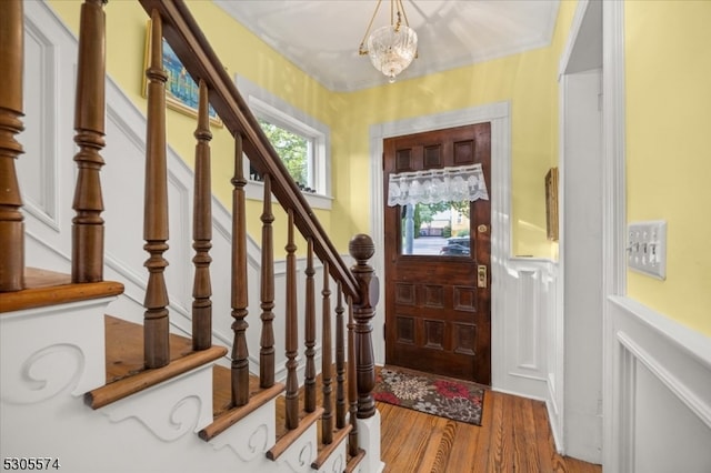 entryway with hardwood / wood-style flooring and crown molding