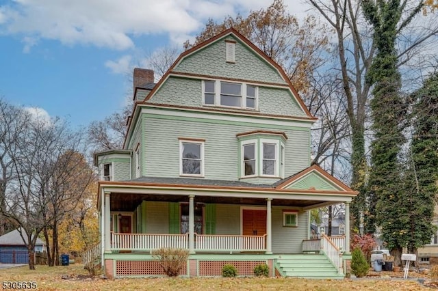 victorian-style house with covered porch, a chimney, and a gambrel roof