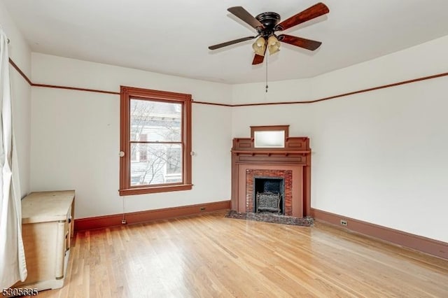 unfurnished living room featuring a brick fireplace, light hardwood / wood-style flooring, and ceiling fan