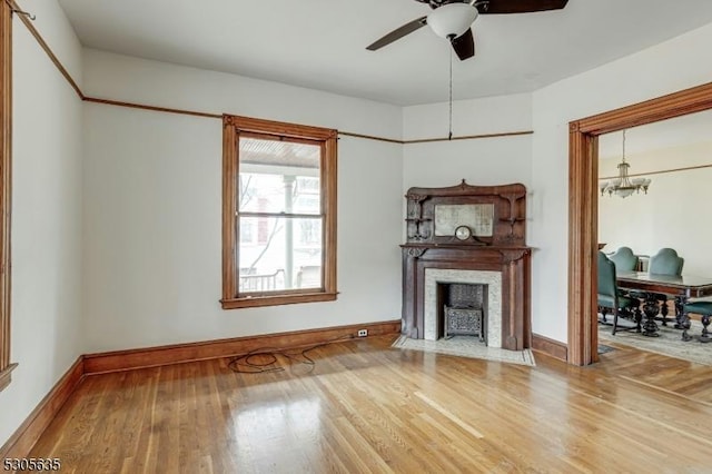 living room featuring ceiling fan with notable chandelier and hardwood / wood-style flooring