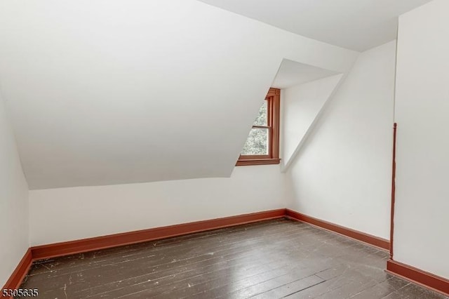 bonus room featuring dark wood-type flooring and lofted ceiling