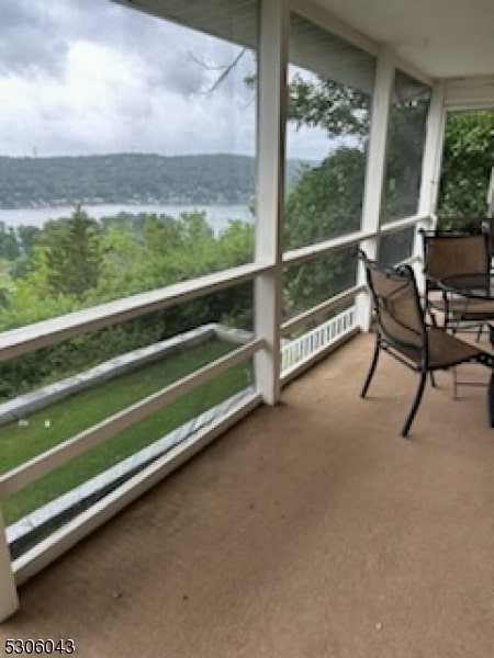 sunroom / solarium featuring a water view