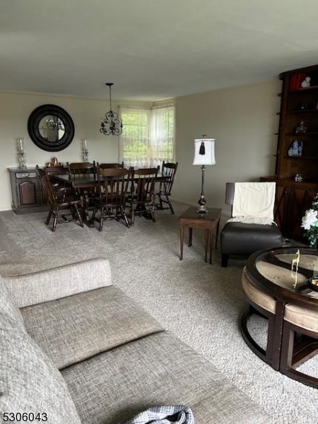 carpeted living room featuring a notable chandelier