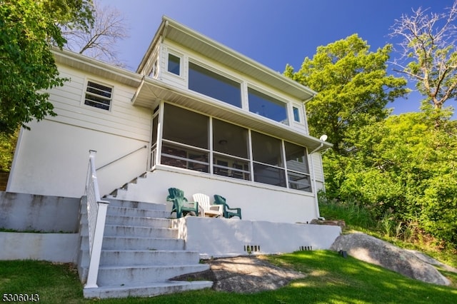 rear view of property featuring a sunroom