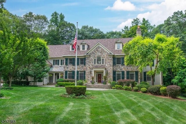 colonial-style house featuring a front lawn