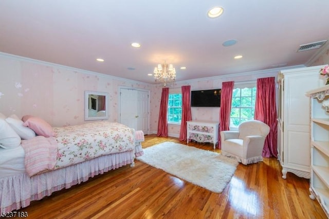 bedroom with crown molding, a notable chandelier, and light hardwood / wood-style flooring