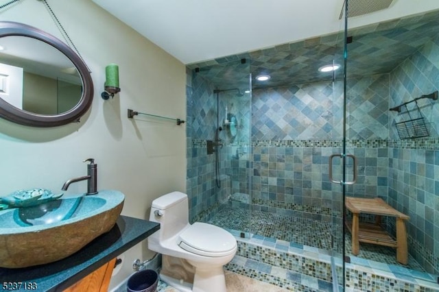 bathroom featuring vanity, an enclosed shower, and toilet