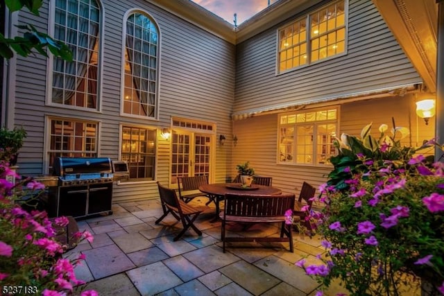 back house at dusk featuring a patio area