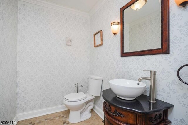 bathroom with tile patterned floors, ornamental molding, vanity, and toilet