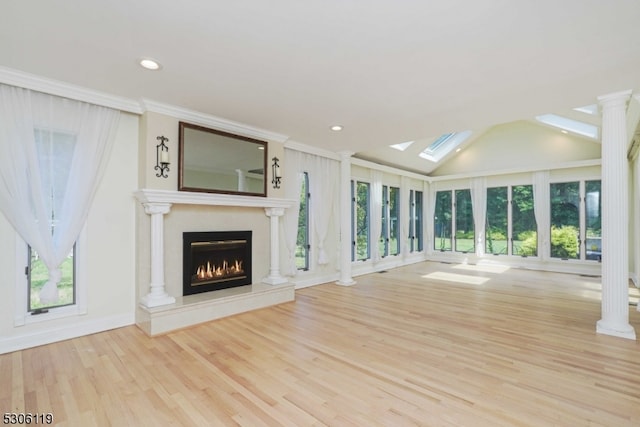 unfurnished living room with vaulted ceiling with skylight, light hardwood / wood-style flooring, and a healthy amount of sunlight