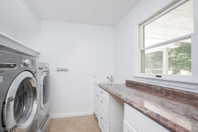 laundry room with sink, washing machine and clothes dryer, light tile patterned floors, and cabinets