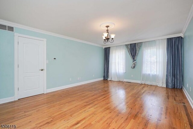 unfurnished room featuring light hardwood / wood-style flooring, a chandelier, and crown molding