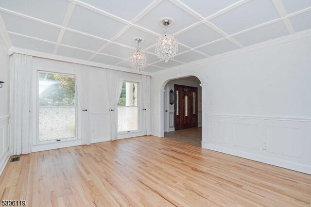 unfurnished room featuring coffered ceiling and light wood-type flooring