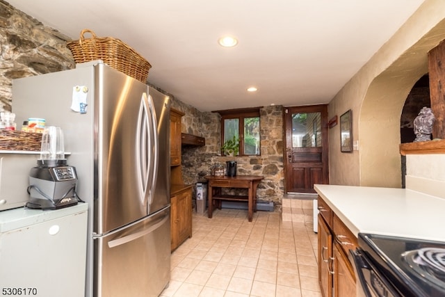 kitchen with stainless steel fridge, range, and light tile patterned floors