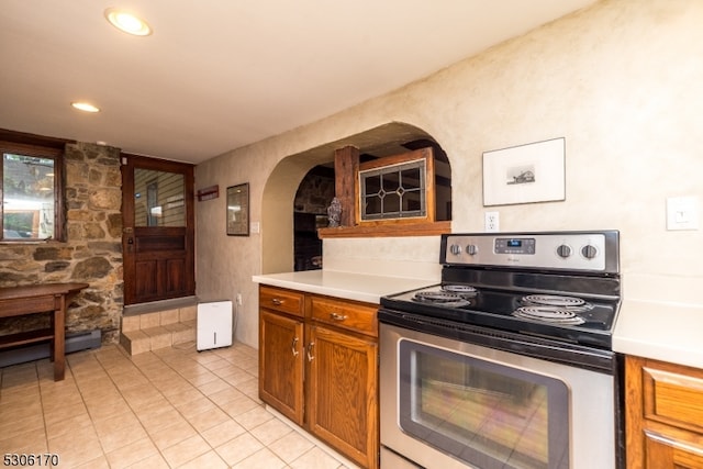 kitchen with light tile patterned floors and stainless steel range with electric stovetop