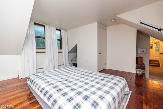 bedroom featuring dark wood-type flooring, vaulted ceiling, and a baseboard radiator