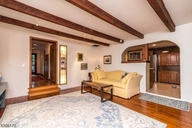 living room featuring beamed ceiling and tile patterned flooring