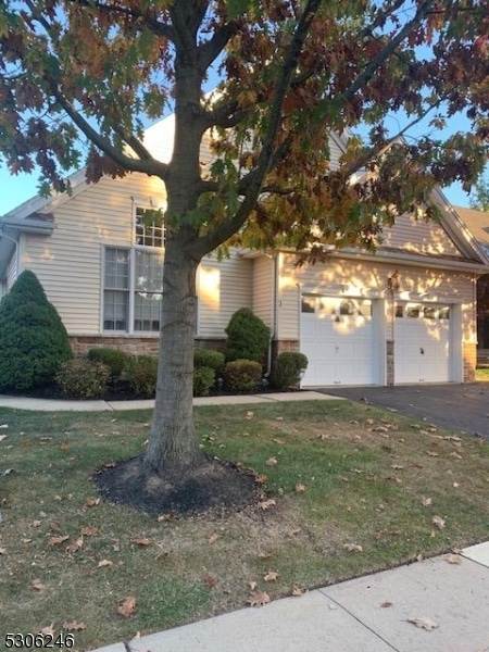 obstructed view of property with a front yard and a garage