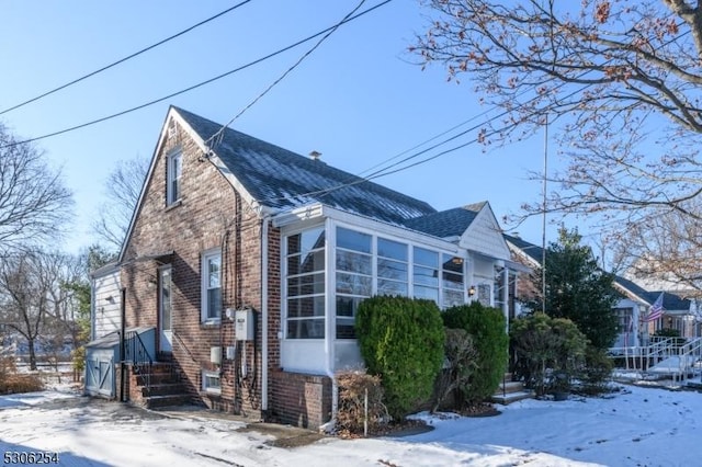 snow covered property with a sunroom