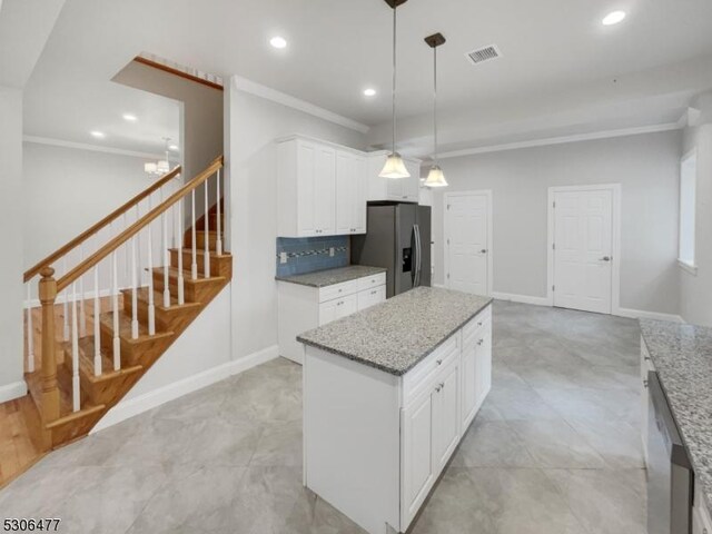 kitchen featuring pendant lighting, stainless steel appliances, backsplash, ornamental molding, and light tile patterned floors