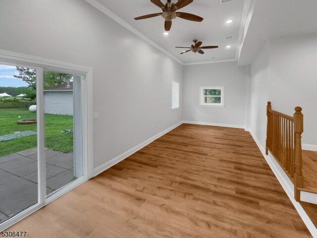 empty room with ornamental molding, plenty of natural light, ceiling fan, and light hardwood / wood-style floors