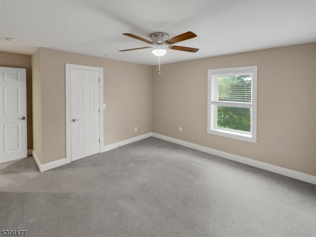 carpeted spare room with ceiling fan