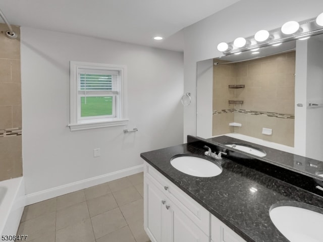 bathroom with tiled shower / bath, double sink vanity, and tile patterned flooring