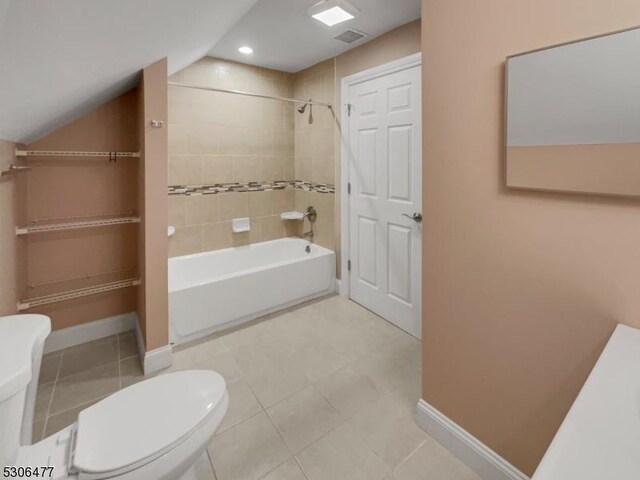 bathroom featuring tile patterned floors, toilet, and tiled shower / bath