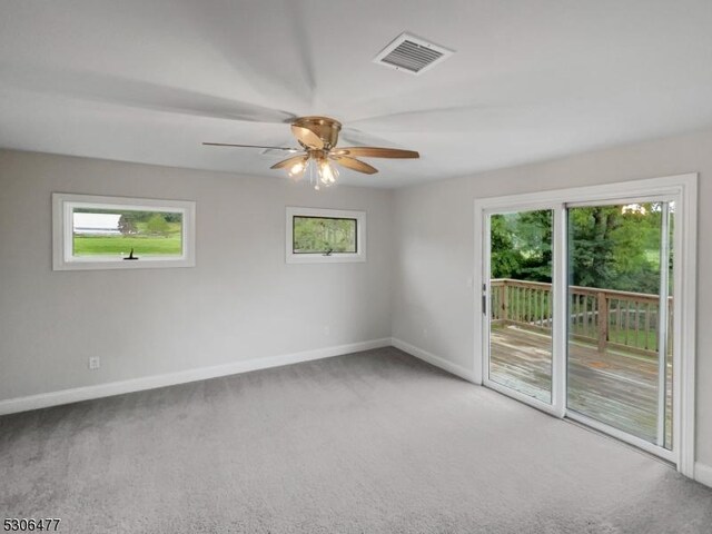 empty room featuring ceiling fan, plenty of natural light, and carpet floors