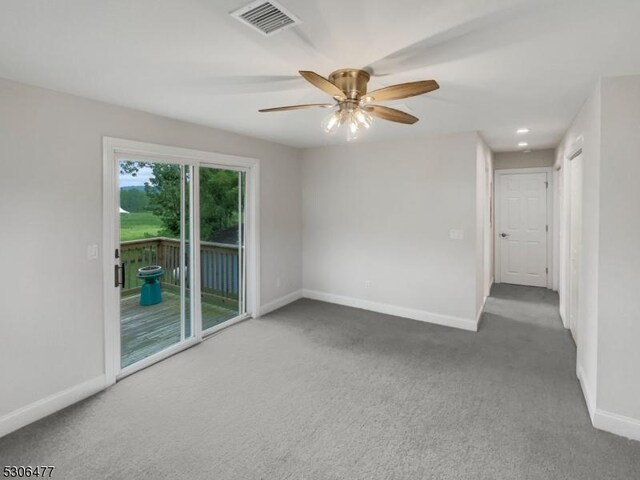 spare room with ceiling fan and carpet