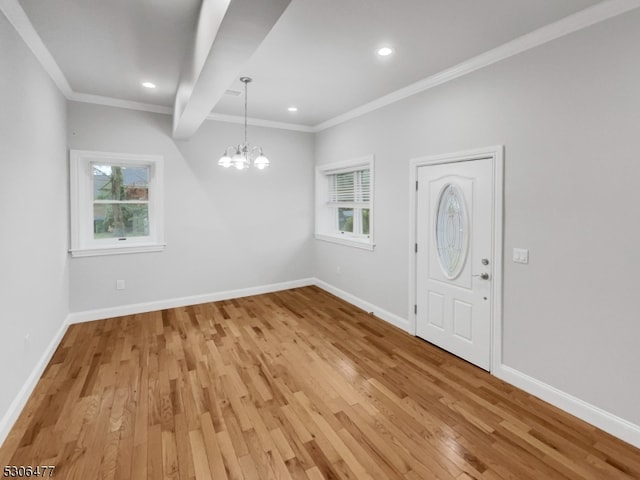 foyer with light wood-type flooring, a wealth of natural light, and an inviting chandelier