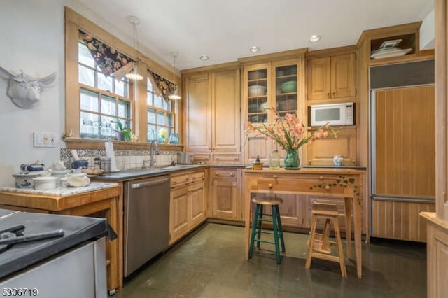 kitchen featuring sink, decorative light fixtures, decorative backsplash, and built in appliances