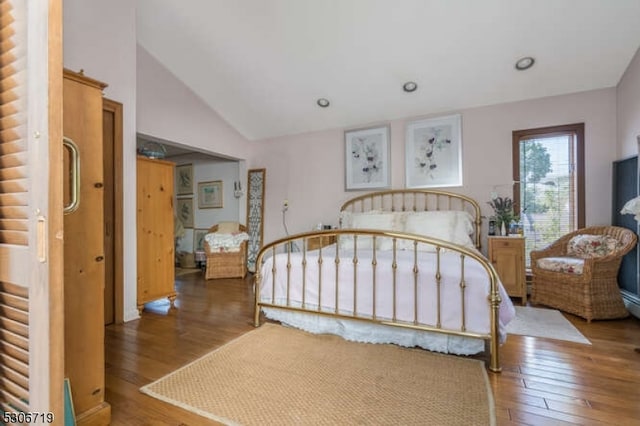 bedroom featuring high vaulted ceiling and hardwood / wood-style floors