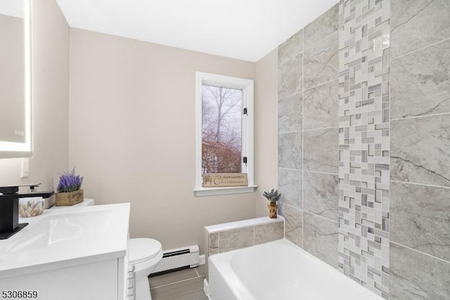 bathroom with a tub, toilet, vanity, and a baseboard heating unit