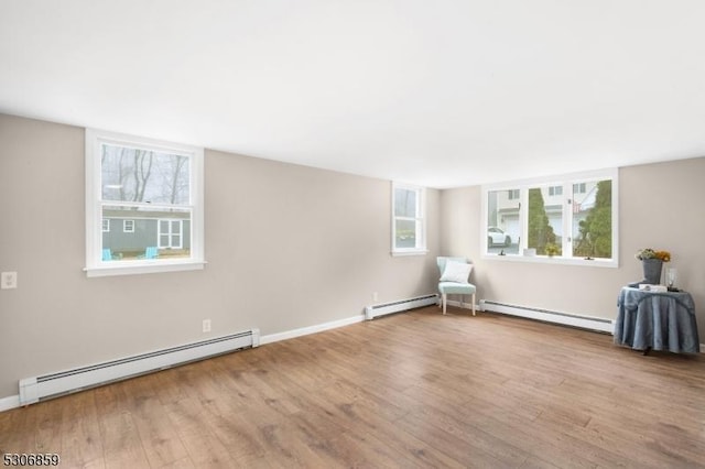 unfurnished room with light wood-type flooring and baseboard heating