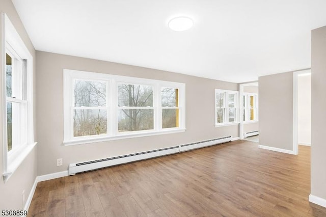 empty room featuring baseboard heating and light wood-type flooring