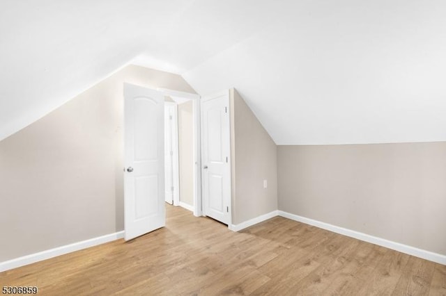 additional living space featuring light hardwood / wood-style floors and lofted ceiling