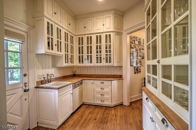 kitchen with light hardwood / wood-style floors, sink, butcher block counters, and white cabinets