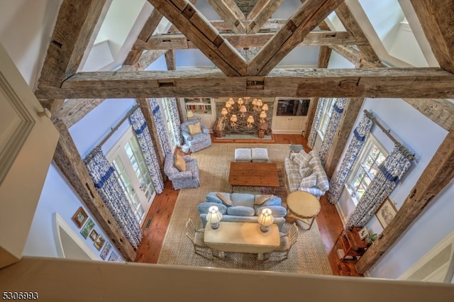 living room with high vaulted ceiling, a healthy amount of sunlight, and hardwood / wood-style floors