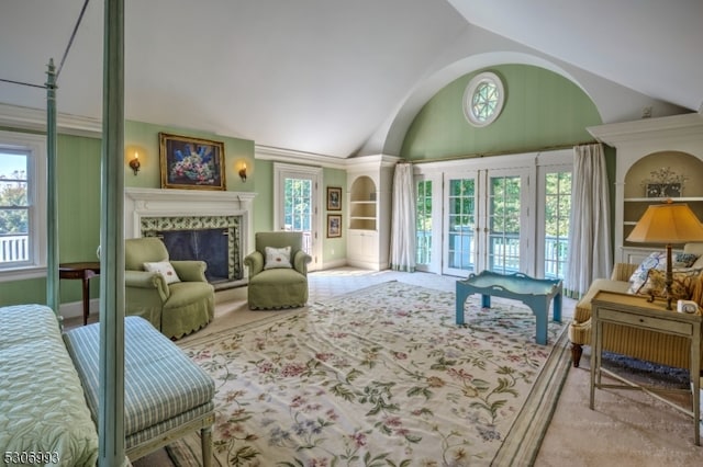 interior space with light carpet, a high end fireplace, vaulted ceiling, and french doors