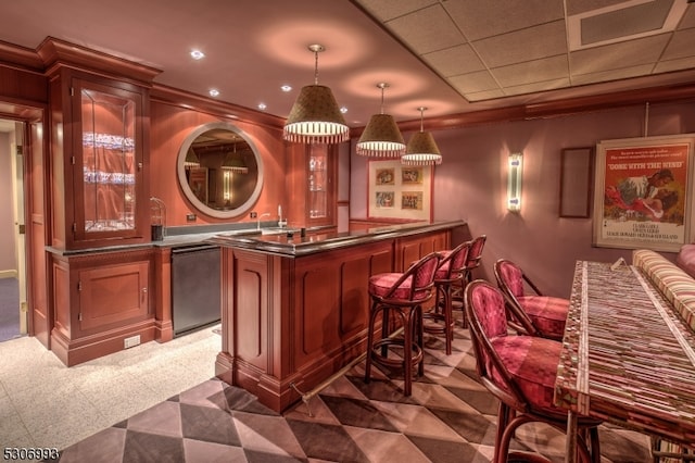 bar with dark colored carpet, crown molding, decorative light fixtures, and dishwashing machine