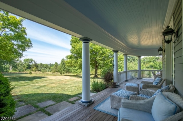 wooden deck featuring a porch and a yard