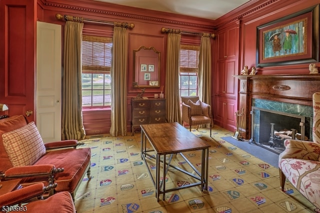 living area featuring a wealth of natural light, a high end fireplace, and crown molding